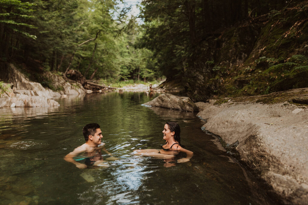 Couple wades in swimming hole in Warren, Vermont